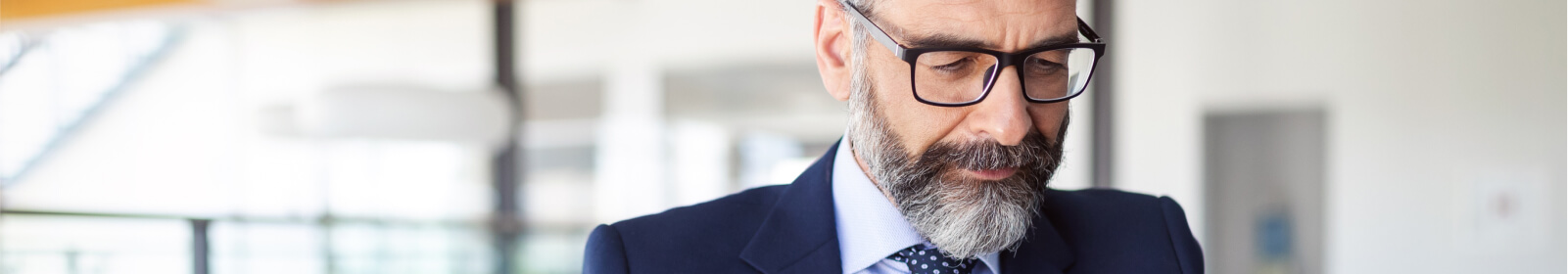 a man wearing glasses in a suit