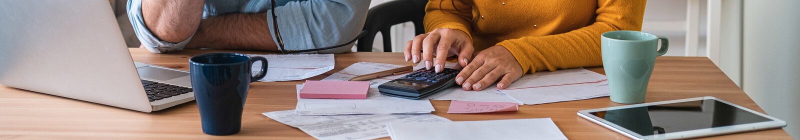 two people working on their finances using a calculator