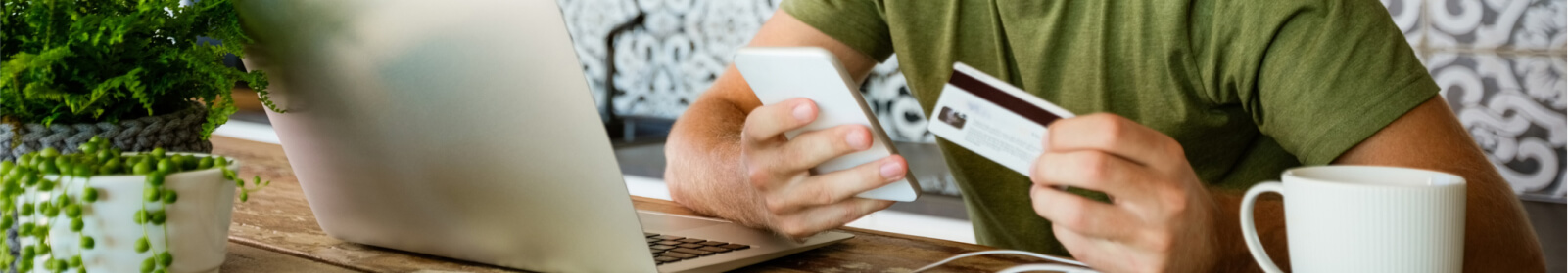 a person holding their credit/debit card to make a mobile purchase